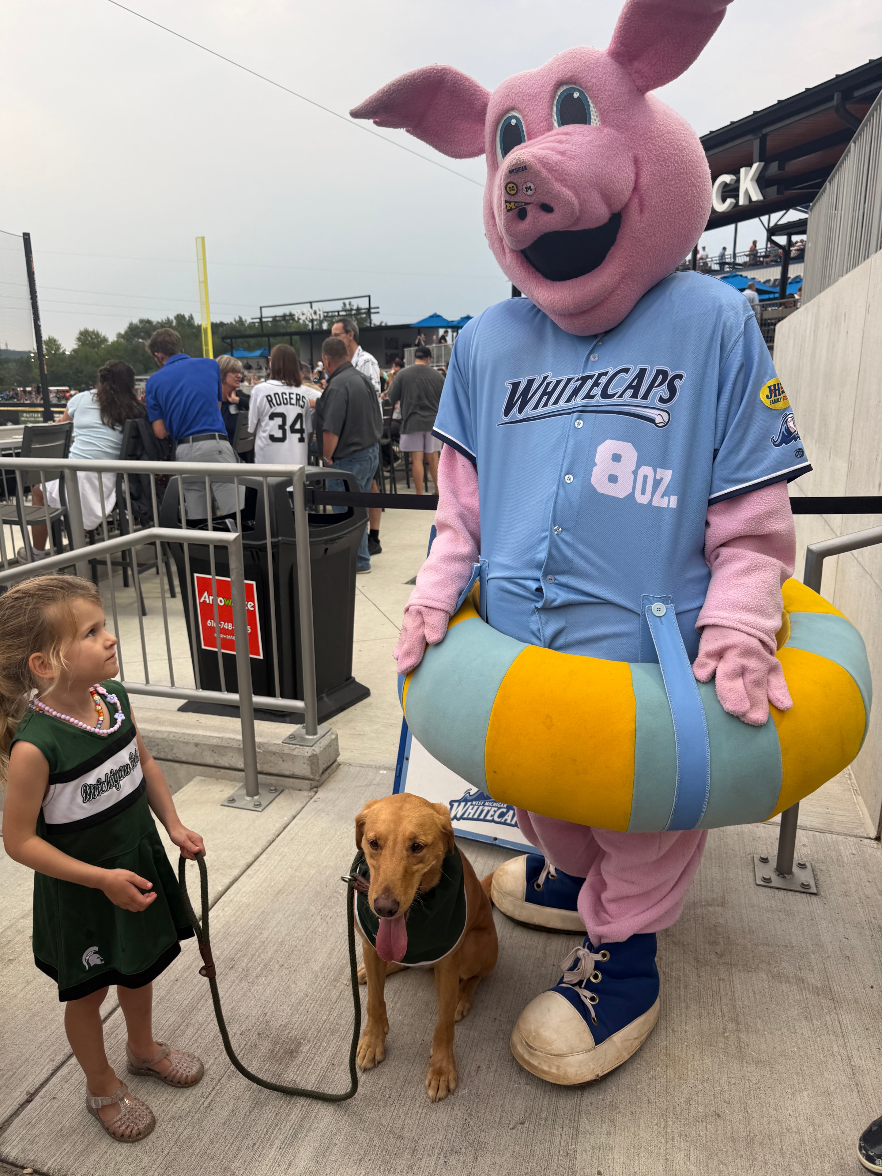 Zeke with the Whitecaps mascot and a young fan
